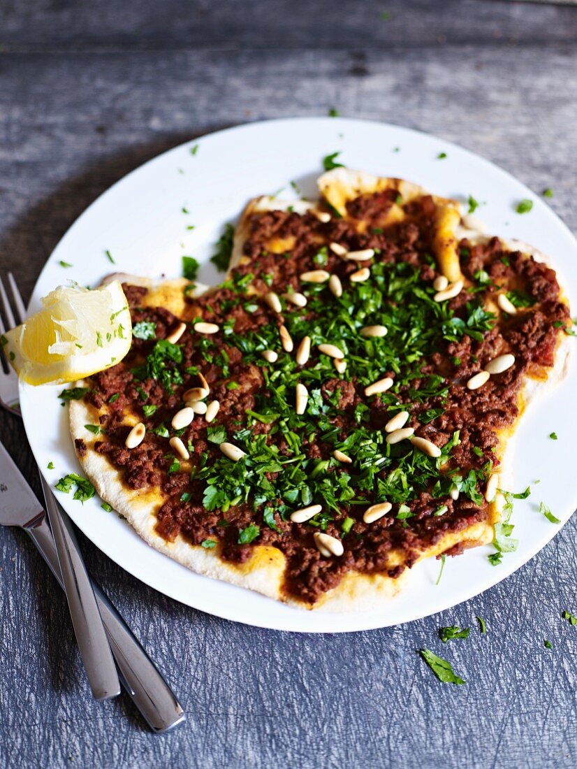 Turkish pizza topped with minced meat and pine nuts