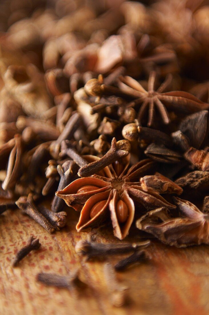 Cloves and star anise on a wooden surface (close-up)