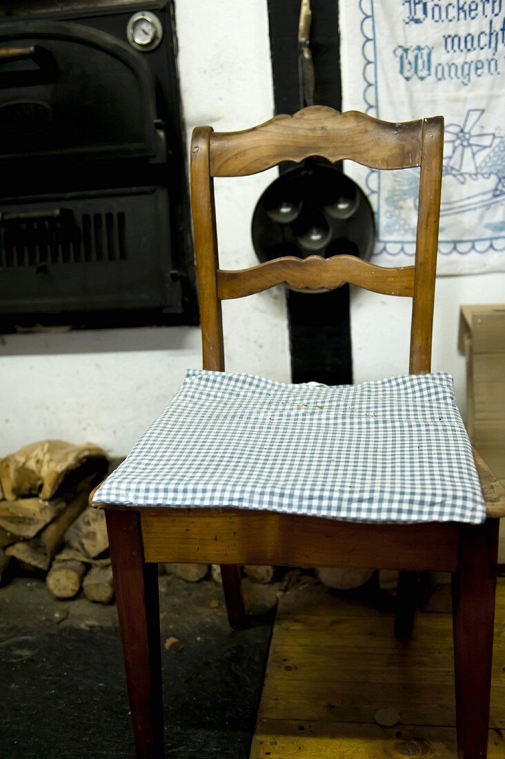 An old wooden chair with a checked cushion