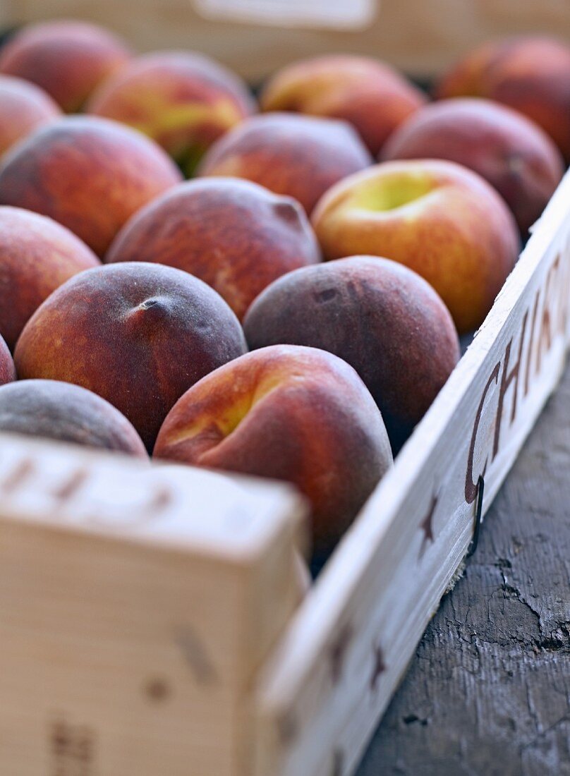 Fresh peaches in a wooden crate