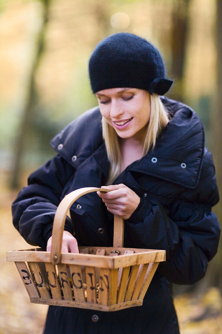 A woman collecting mushrooms in an autumnal forest