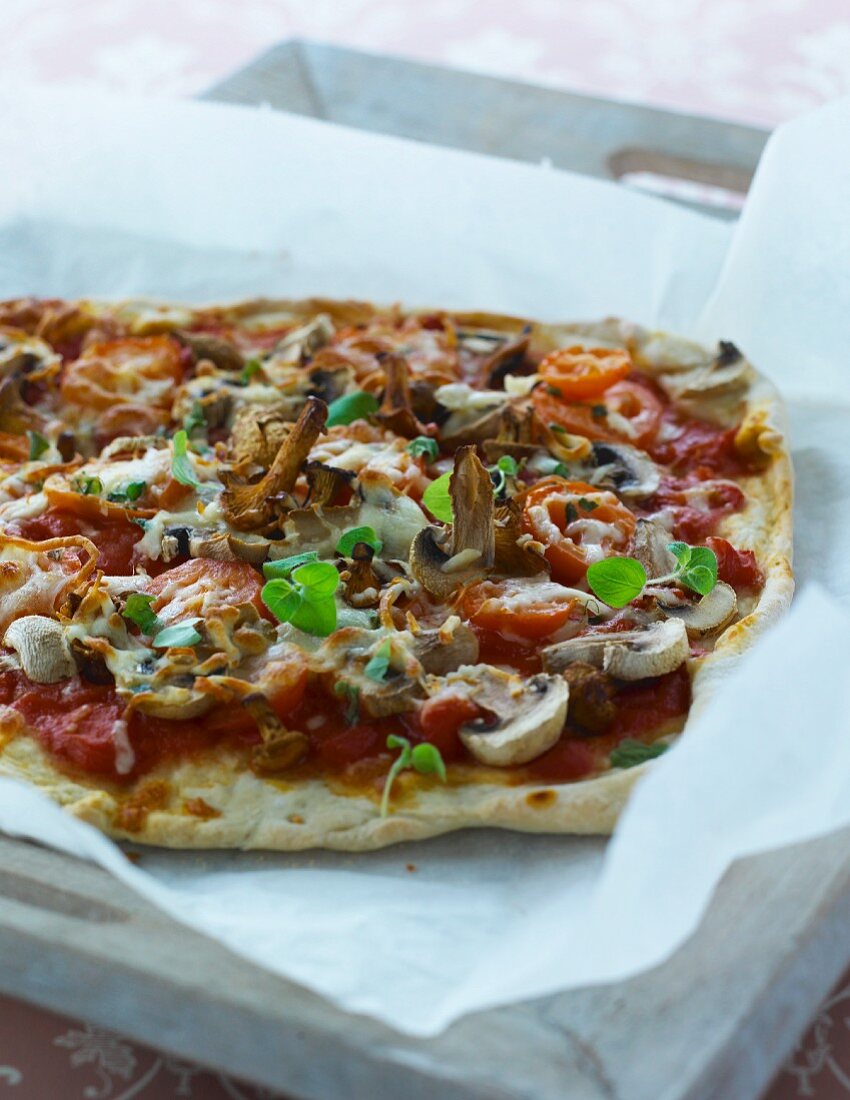 A pizza topped with mushrooms and tomatoes