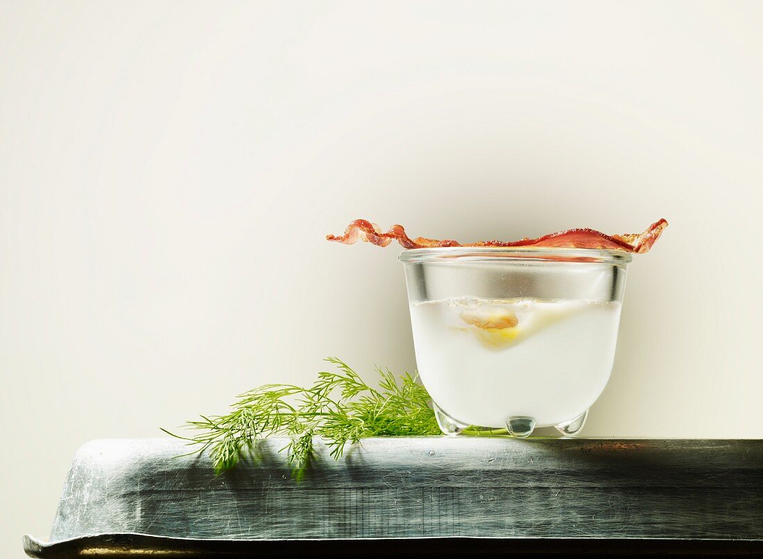 Egg in a glass with bacon and dill