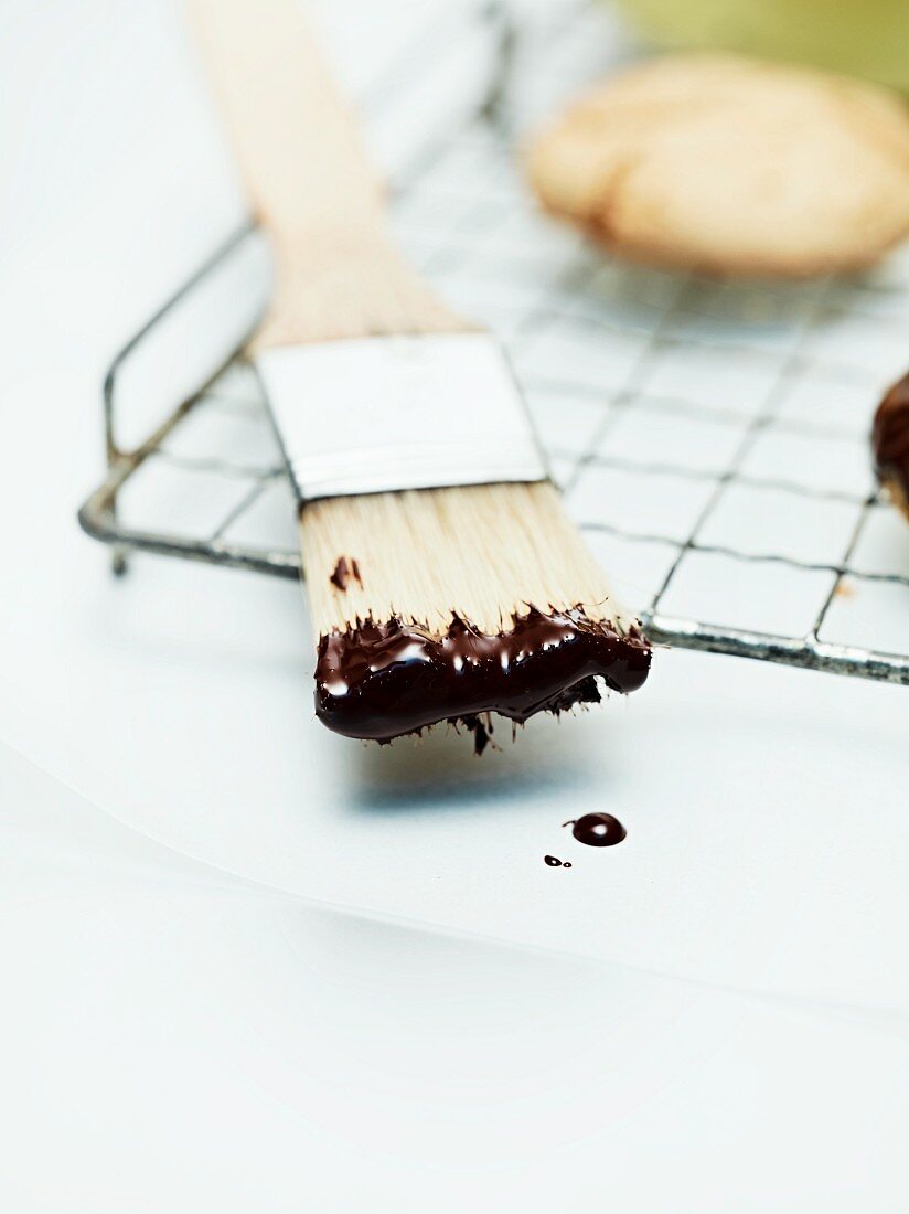 Cooking chocolate on a kitchen brush for decorating gingerbread biscuits