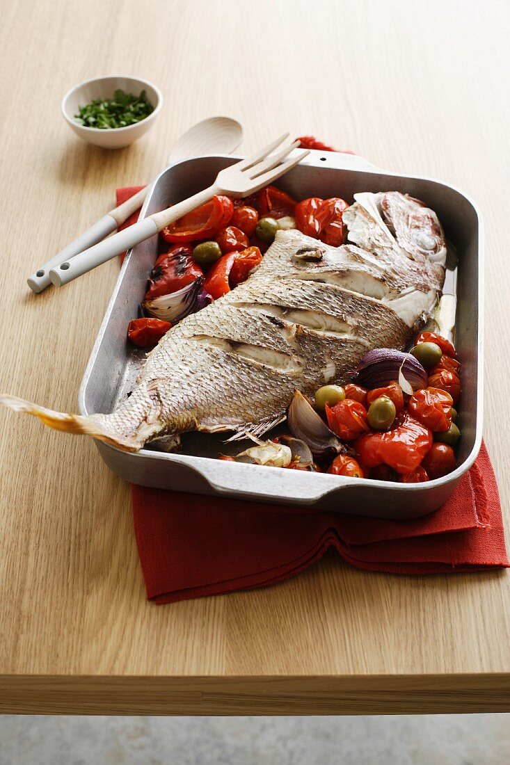 Oven-baked red snapper with tomatoes, pepper and olives