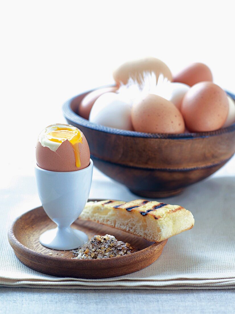 Ein weich gekochtes Ei mit Salzmischung und gegrilltem Pitabrot