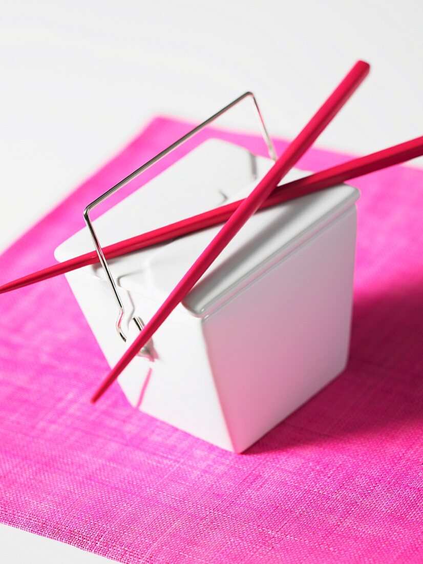 An Asian take-away box with chopsticks