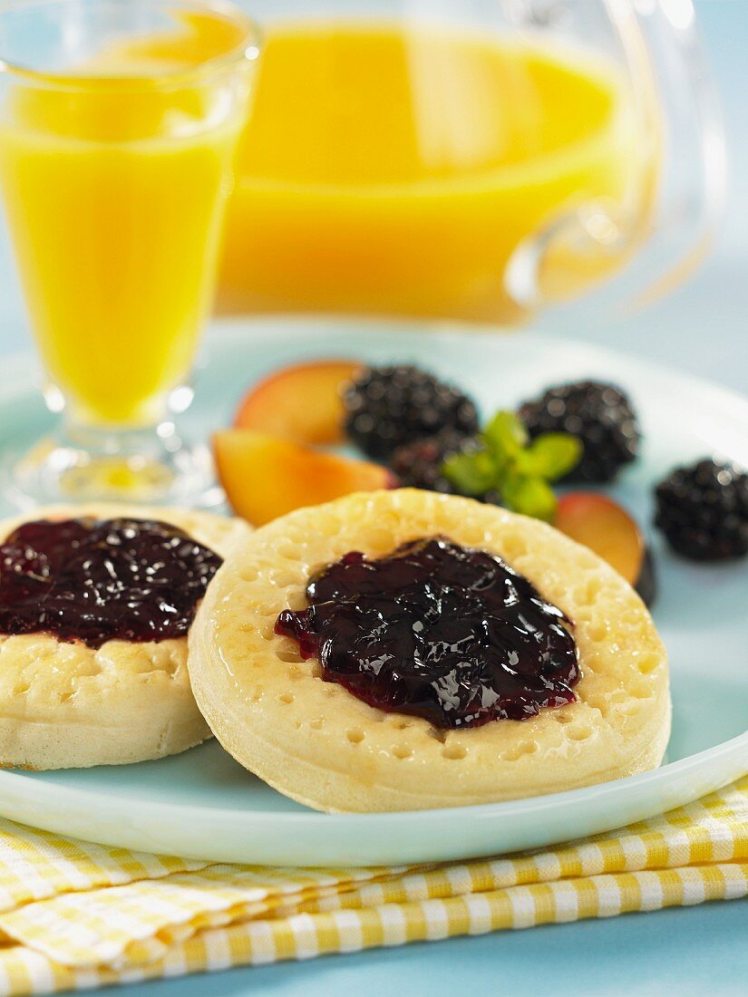 English muffins with plum and blackberry jelly and orange juice