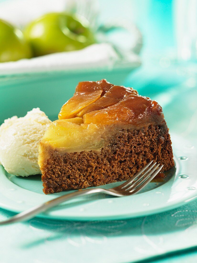 A slice of apple upside down cake with vanilla ice cream