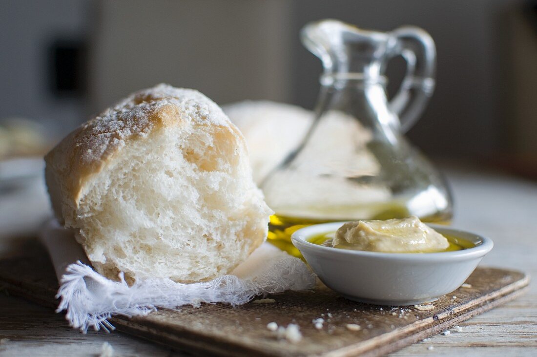 Weißbrot, Olivenöl in Karaffe & Hummus in Schälchen