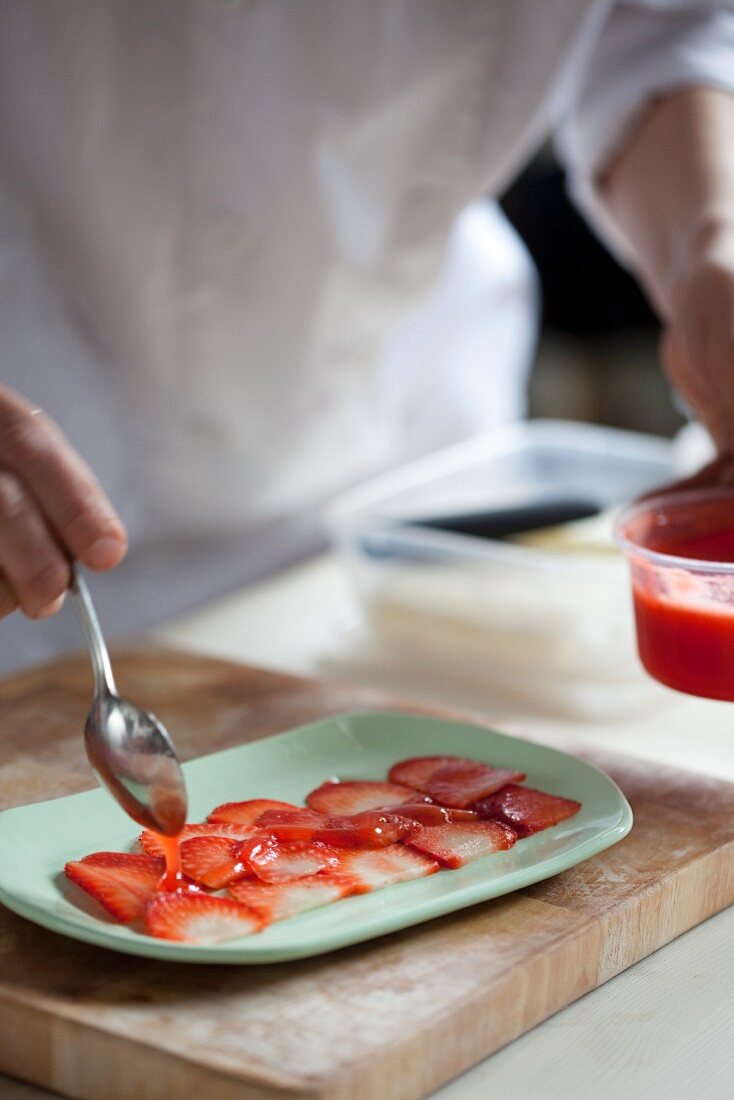 Strawberries being drizzled with jelly
