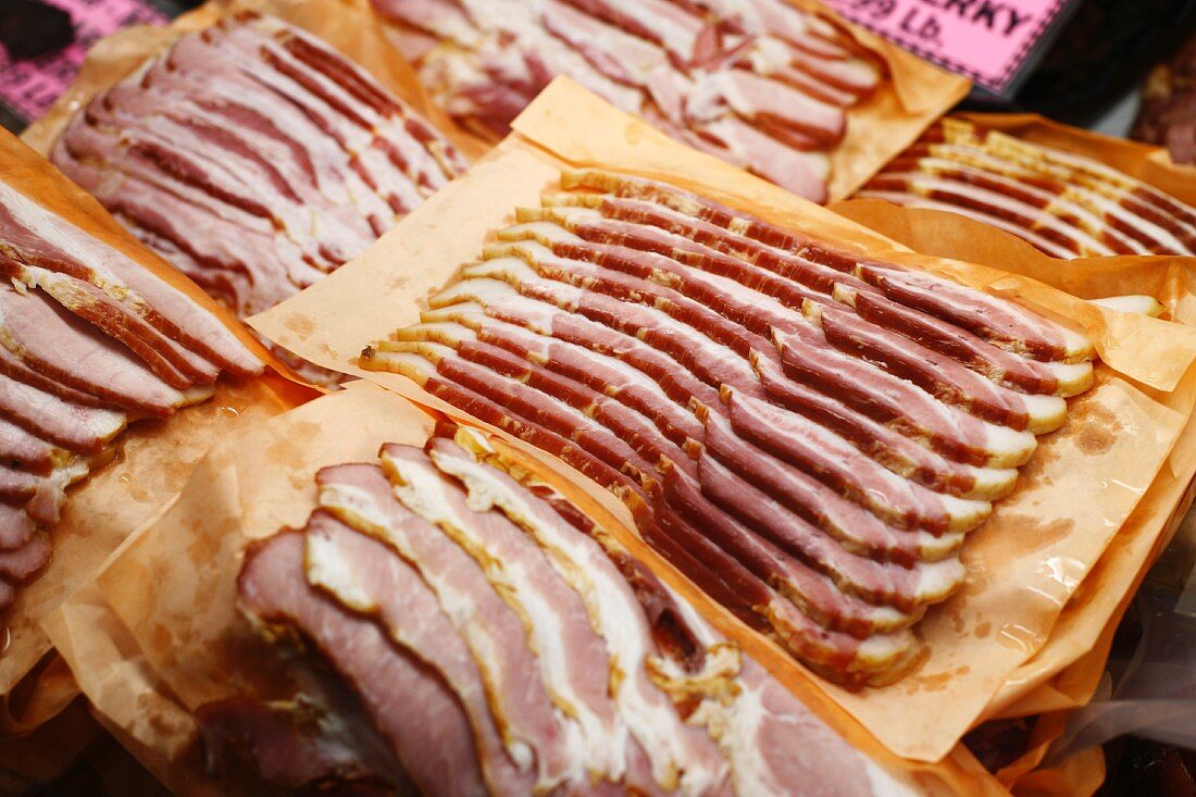 Fresh Slices of Bacon on Paper on Display at Market