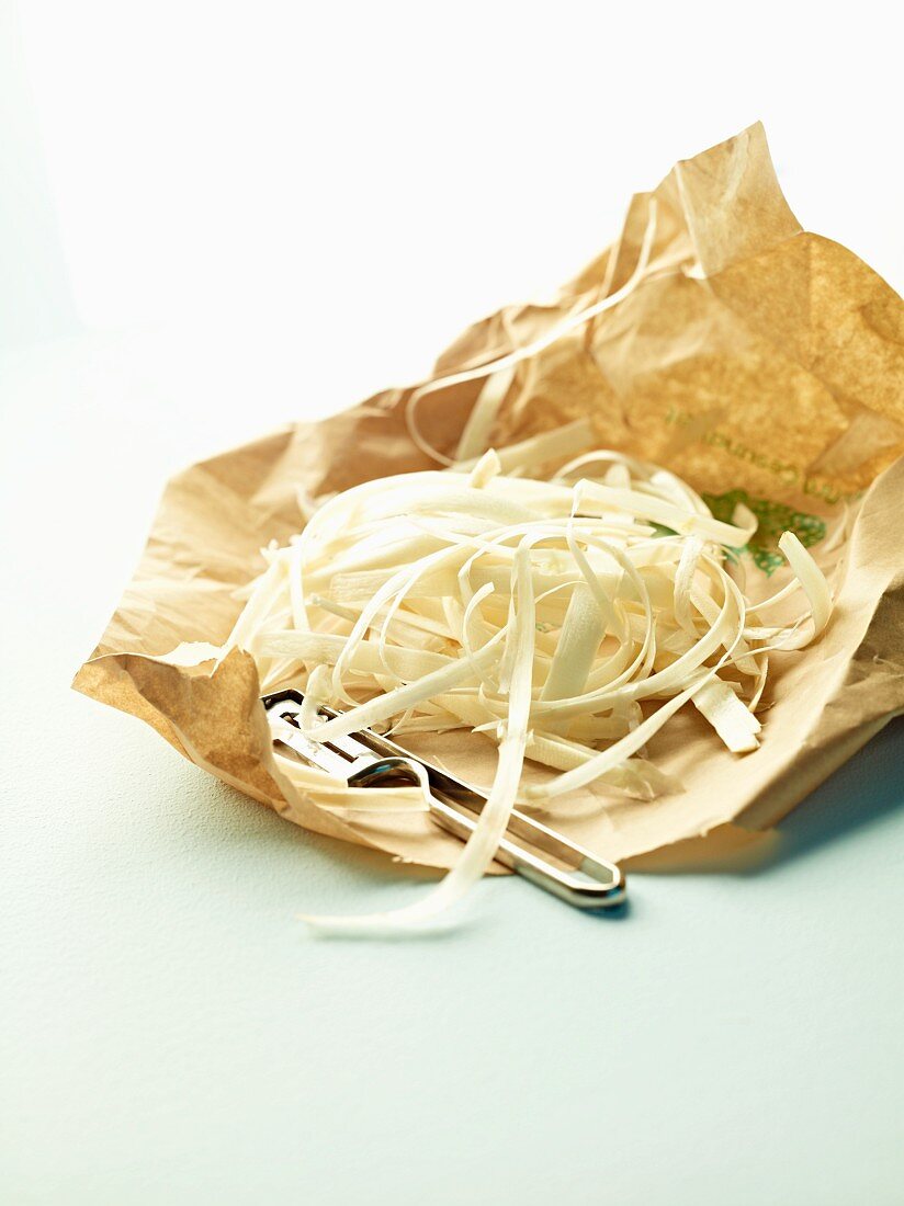Asparagus peel on a paper with a peeler