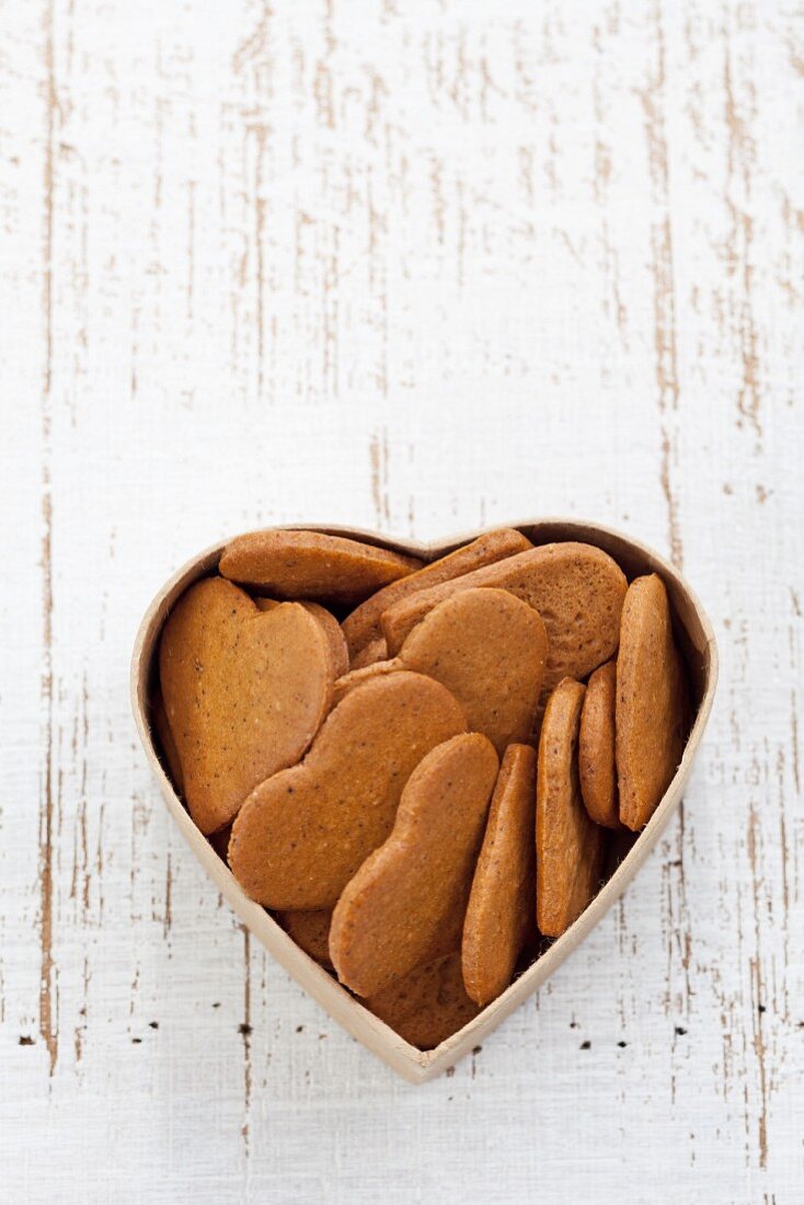 Heart-shaped gingerbread biscuits in a heart-shaped tin