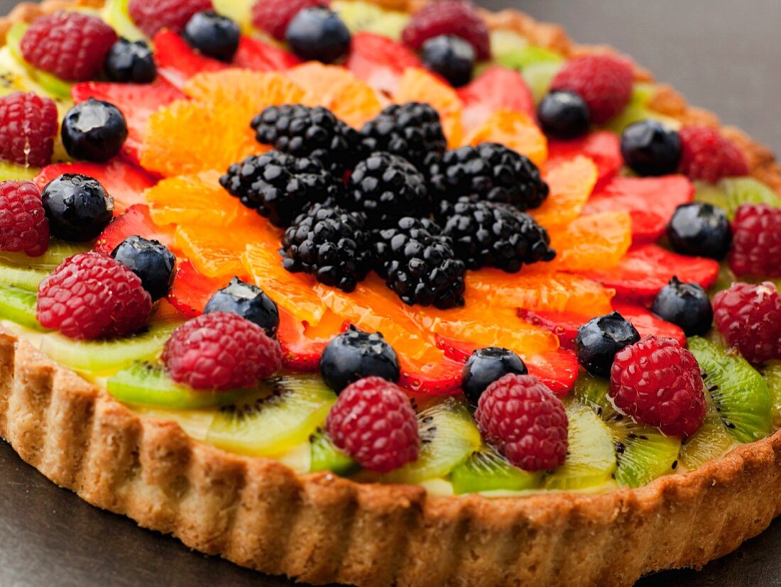 Obsttarte mit Kiwis, Beeren und Orangen