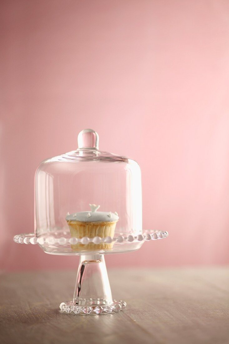 Cupcake auf Tortenständer mit Glashaube