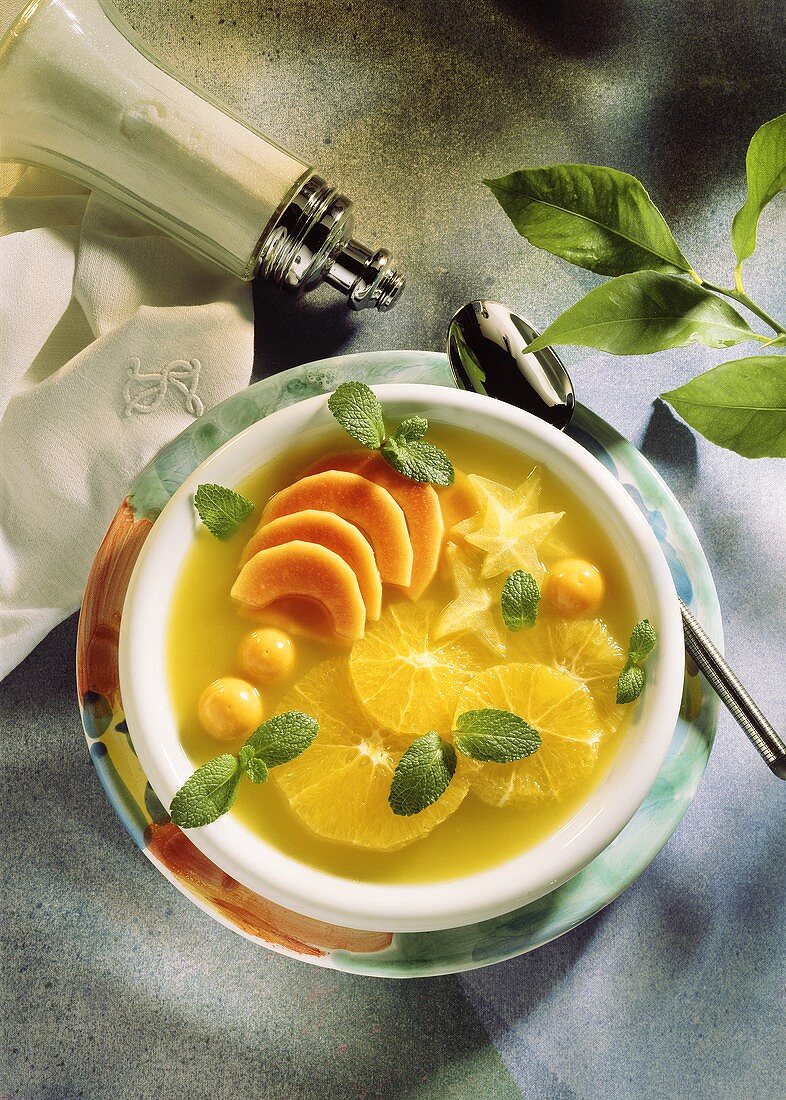 Lime soup with orange slices, kumquats, mango segments