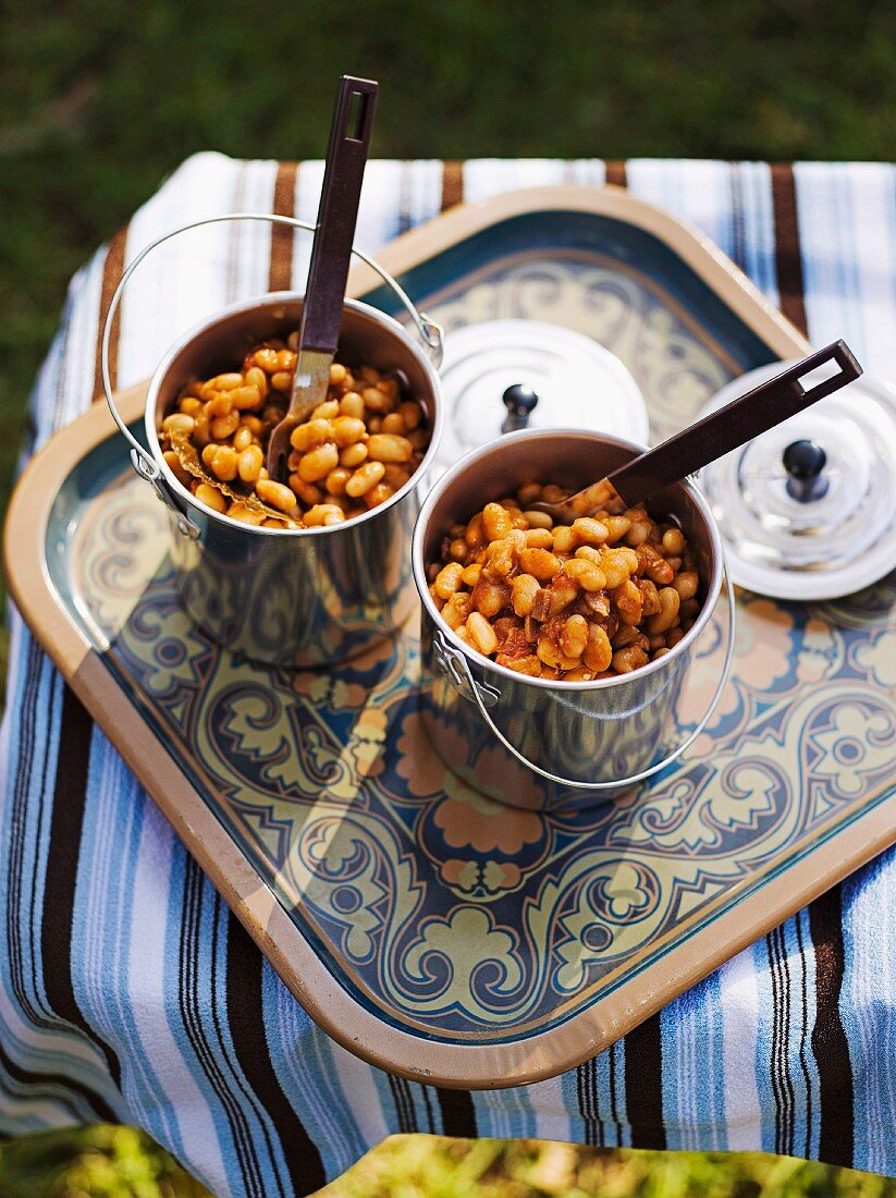 Beans with smoked bacon and maple syrup served in metal cups