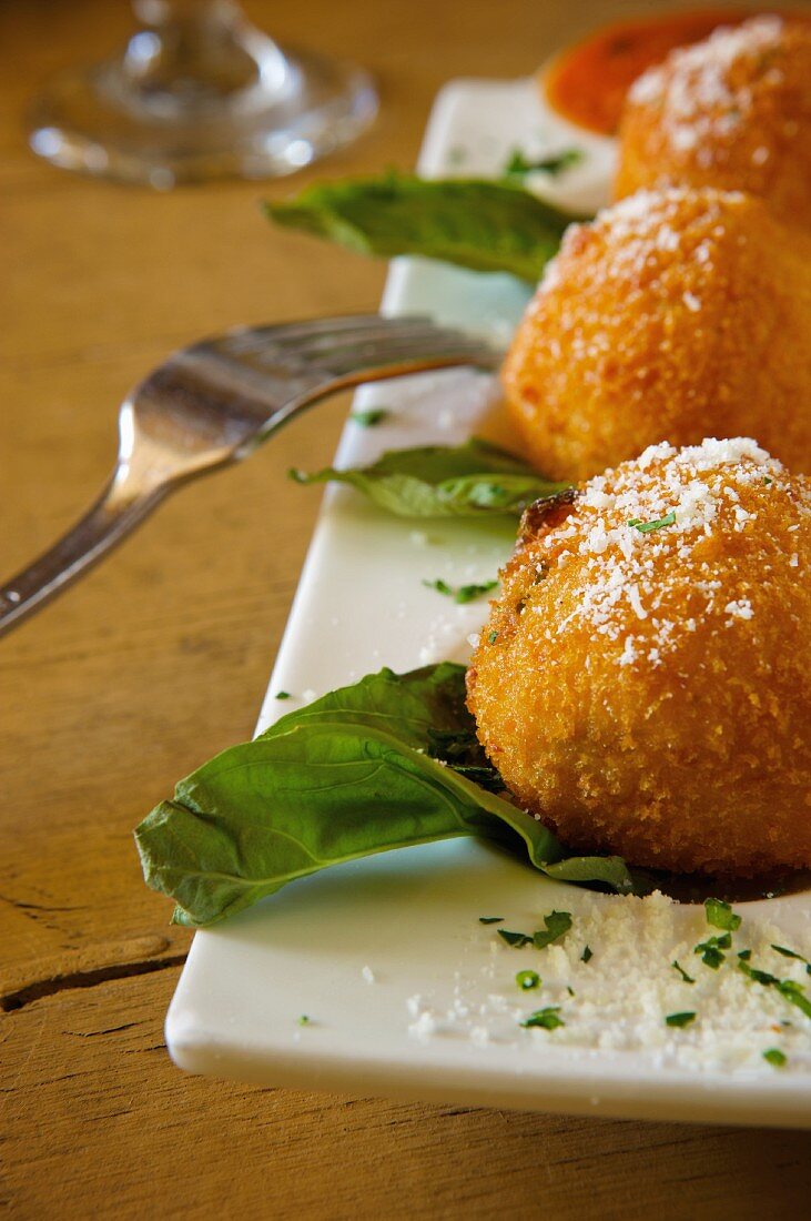 Deep Fried Risotto Balls on a Platter with Parmesan Cheese