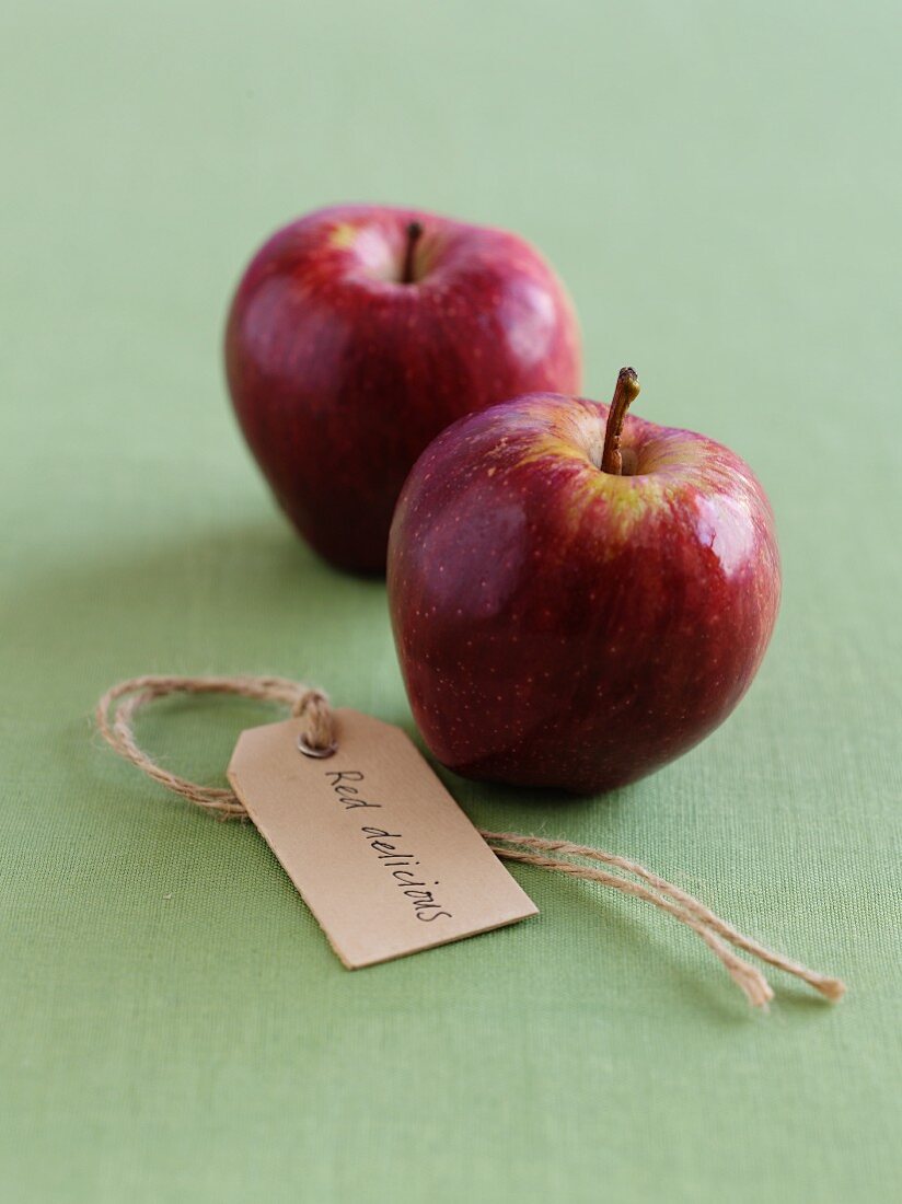 Two Red Delicious apples with a label