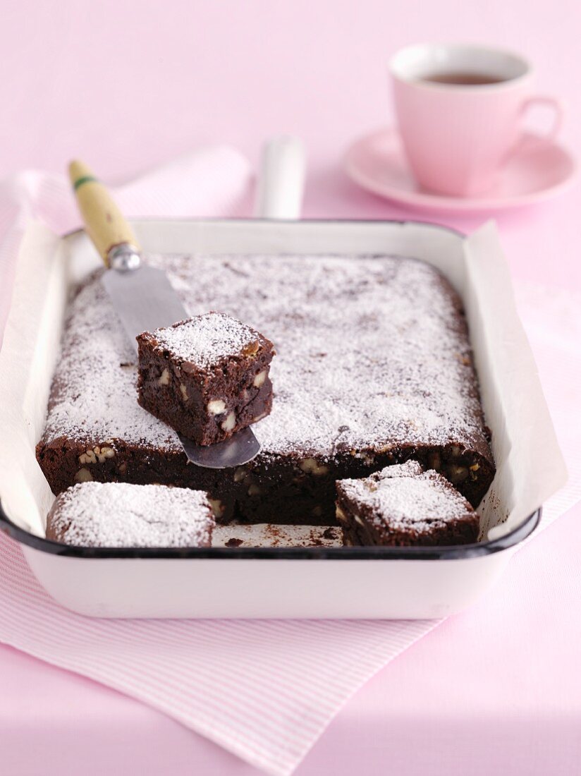 Brownies dusted with icing sugar in a baking dish