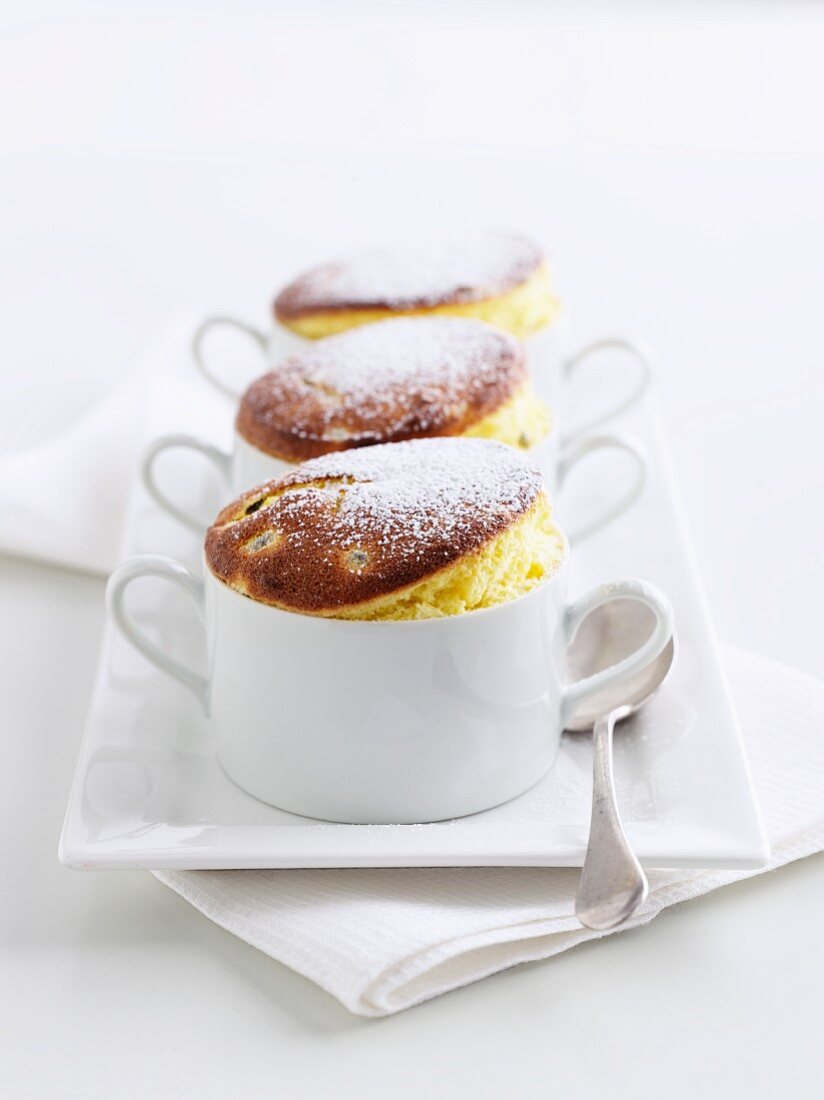 Three souffles with icing sugar in cups
