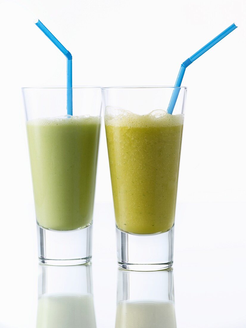 An avocado and citrus fruit smoothie and a mango and basil smoothie
