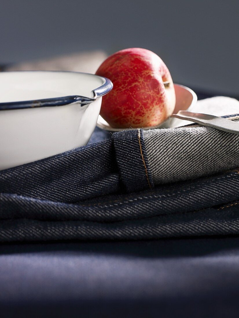 A red apple on top of jeans