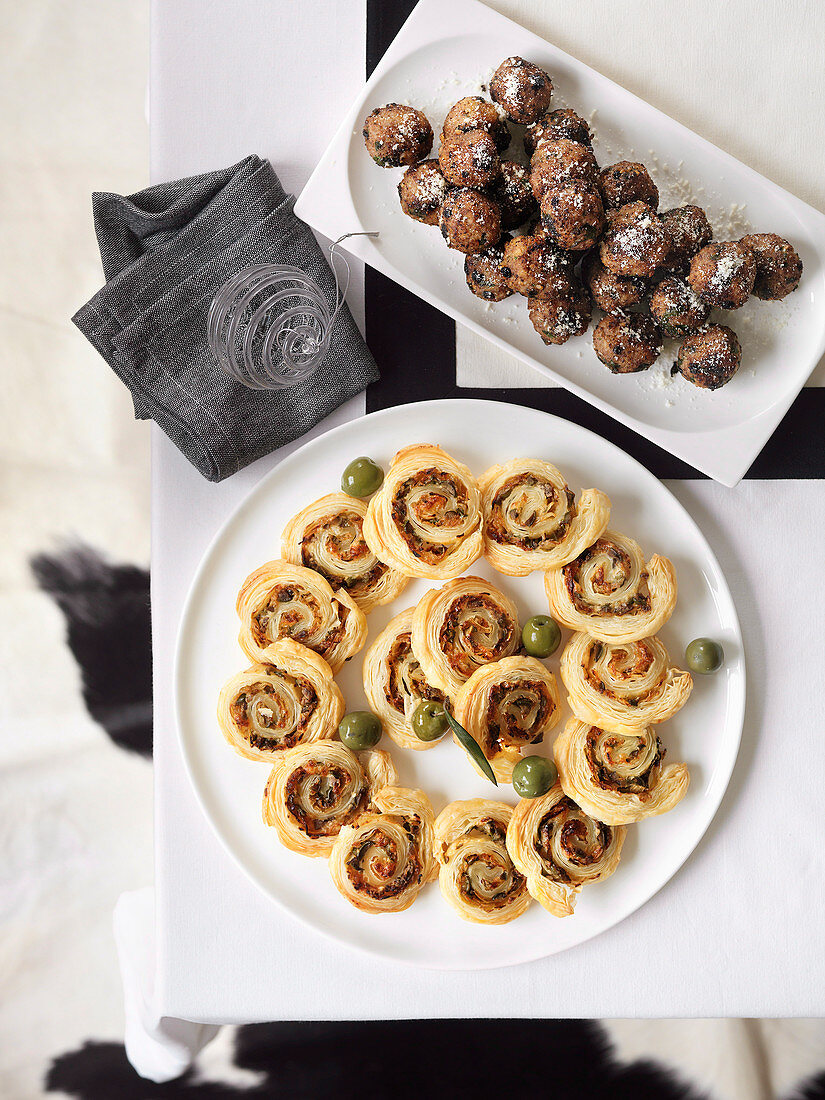 Meat balls with Parmesan and puff pastry spirals filled with anchovies and olives