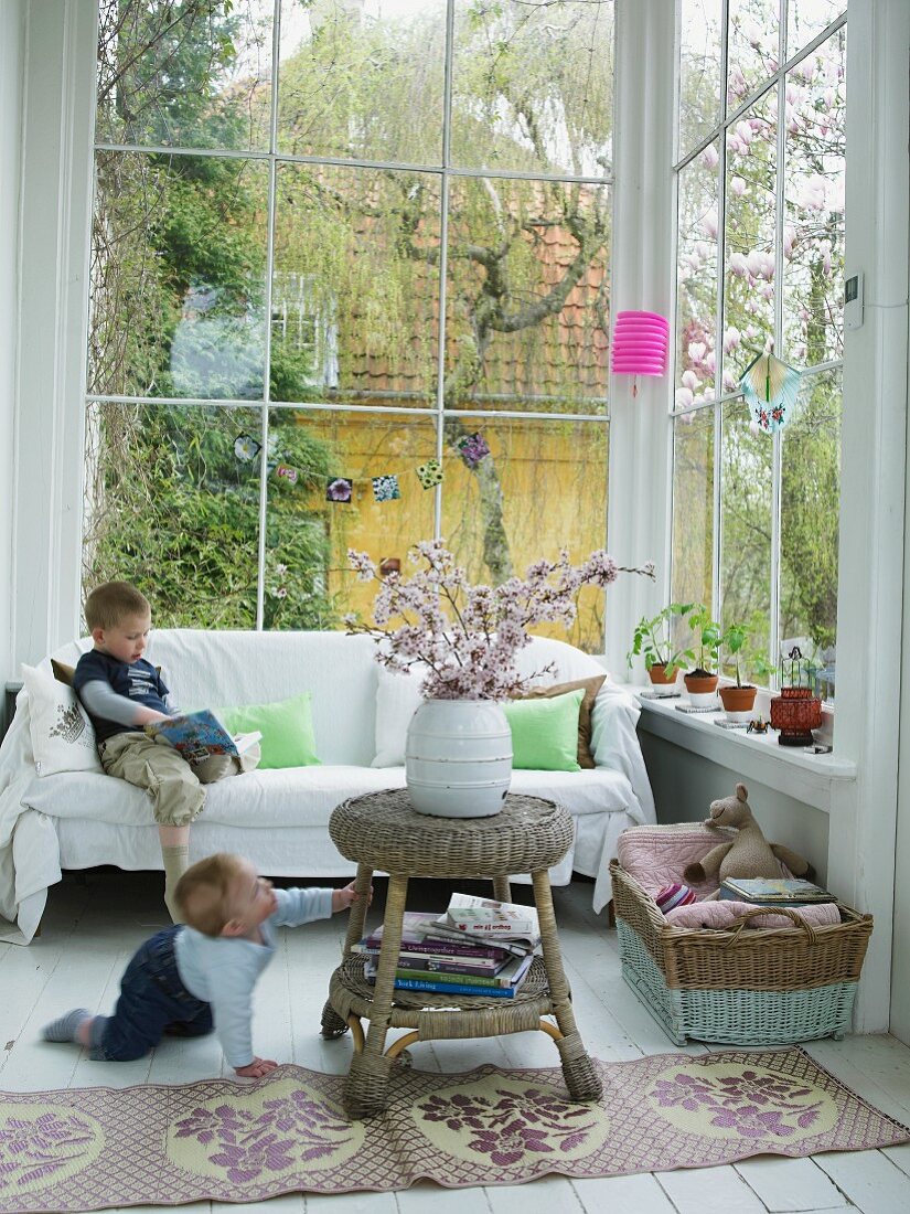Children playing in comfortably-furnished conservatory