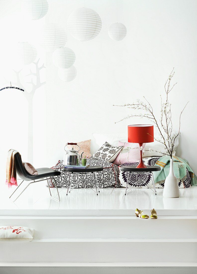 Black, Fifties-style chair and side tables with metal frames on white-painted platform