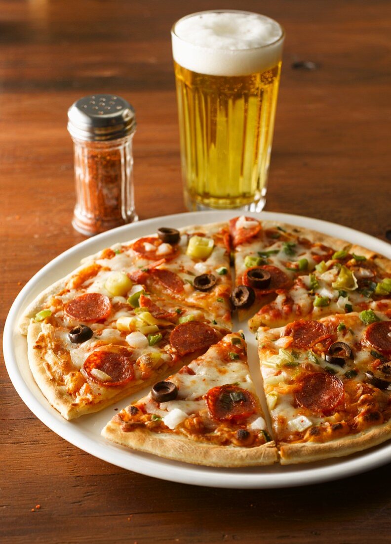 Pizza mit Peperoniwurst, Chilipulver und Bier