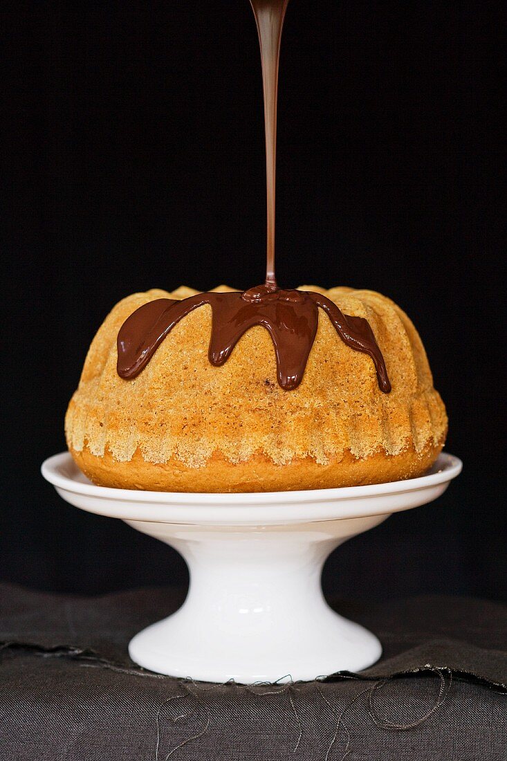 Chocolate glaze being poured over a Madeira Bundt cake