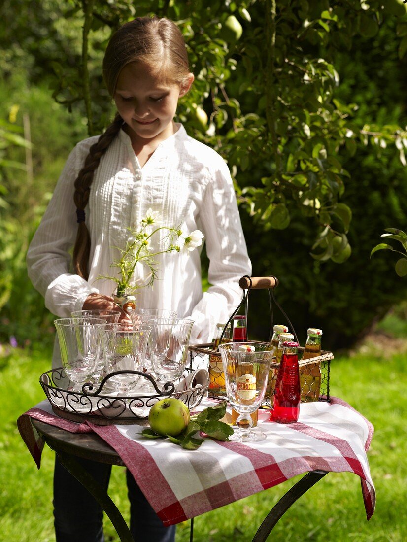 A girl standing outside at a drinks table