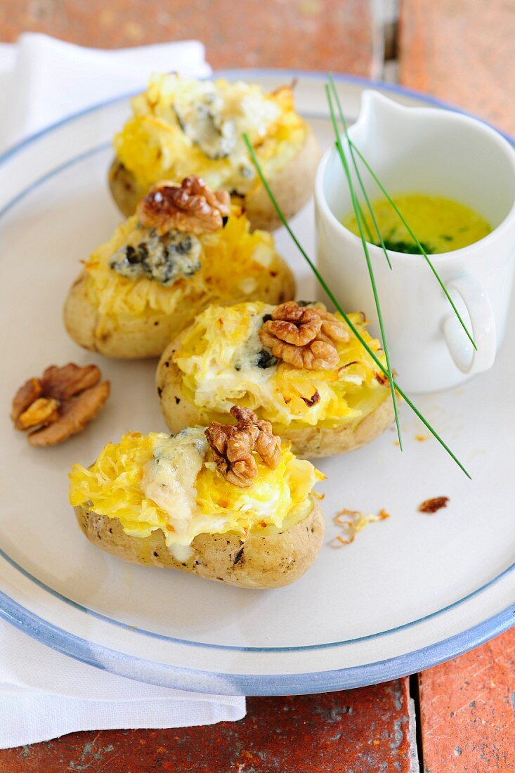 Baked potatoes filled with sauerkraut and blue cheese and served with butter sauce