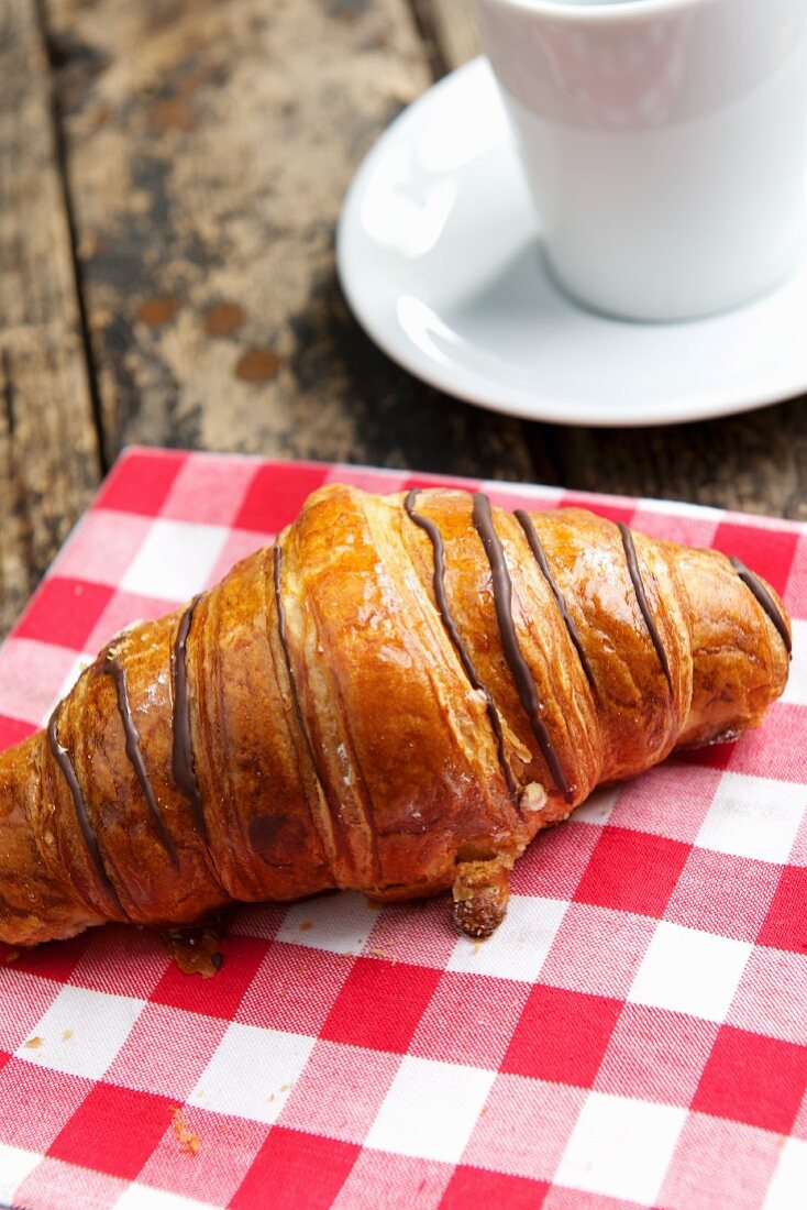 Schokoladencroissant auf kariertem Tuch