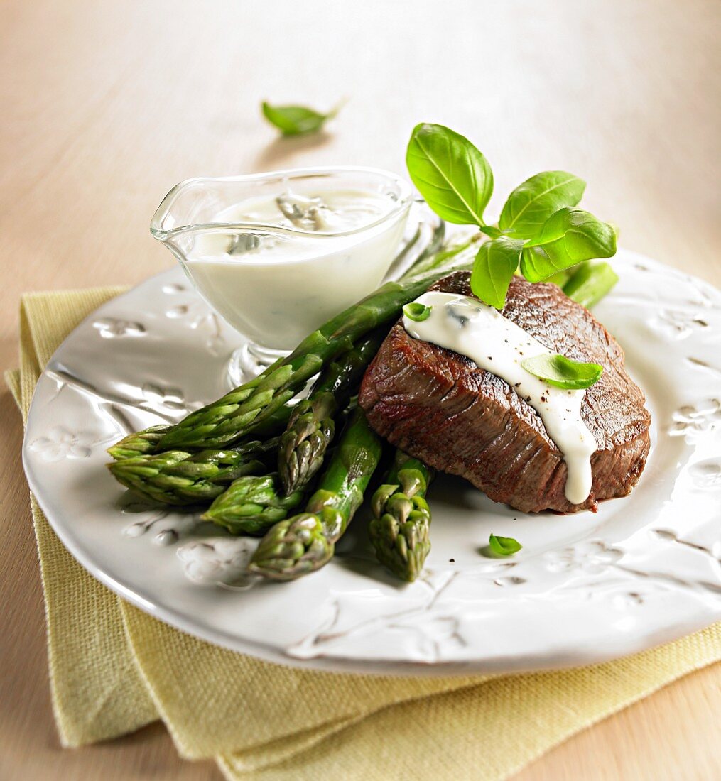 Beef steak with green asparagus and a blue cheese sauce