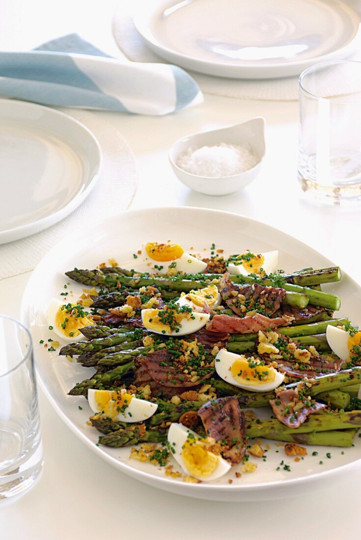 Green asparagus with ham, eggs and garlic crumbs