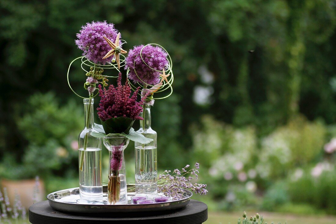 Alliums in bottles decorated with wire and starfish