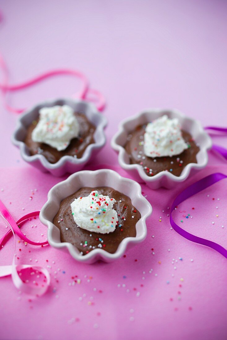 Chocolate pudding with cream and coloured sprinkles