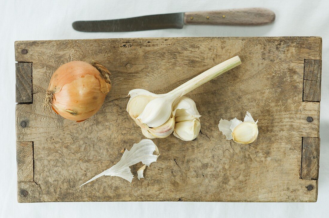 Zwiebel und Knoblauch auf Holzbrett