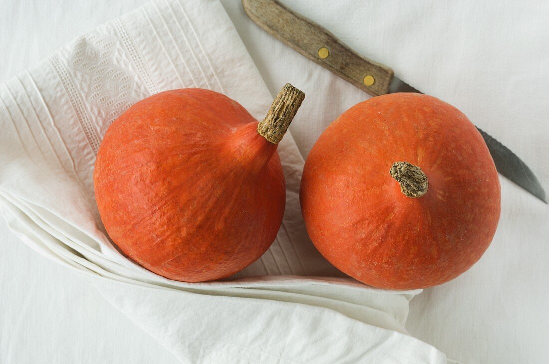 Two Hokkaido pumpkins on a linen cloth