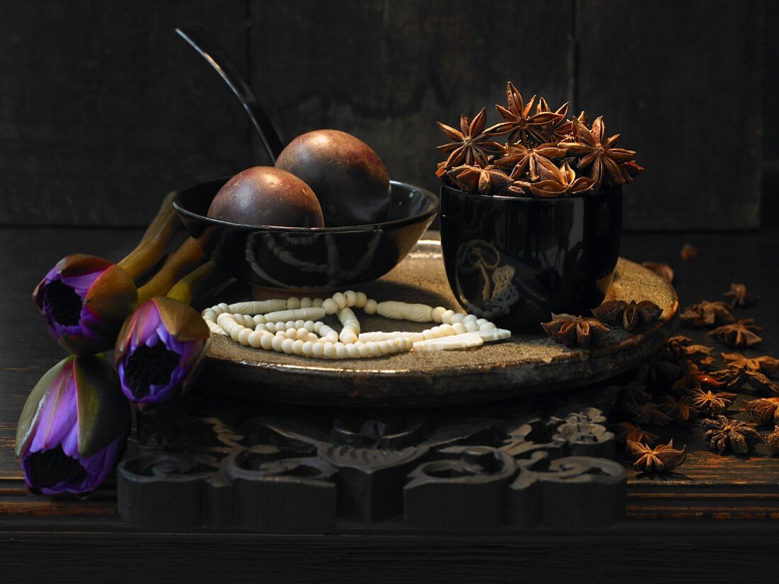 An arrangement of star anise, flowers and passion fruit