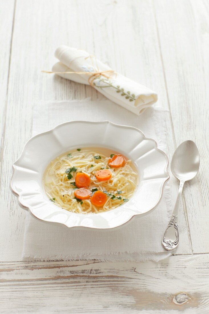 Chicken broth with egg noodles and carrots