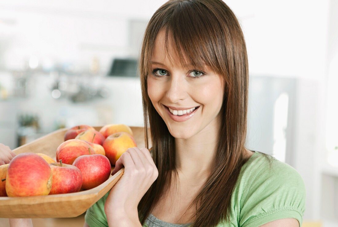 A woman holding a basket of fruit