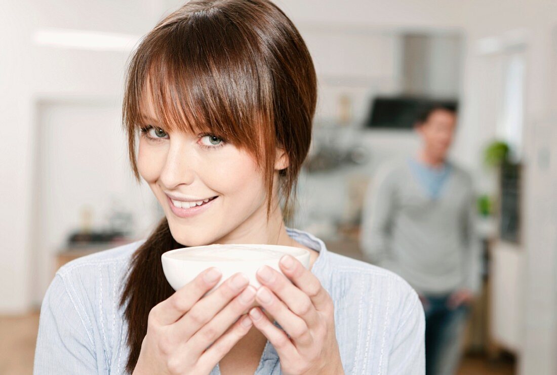 A woman in a kitchen holding a bowl