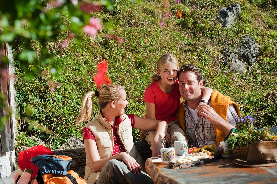 A family eating outside an alpine hut