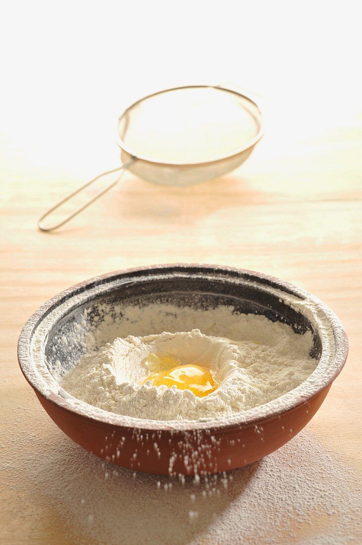 A egg in the middle of a pile of flour