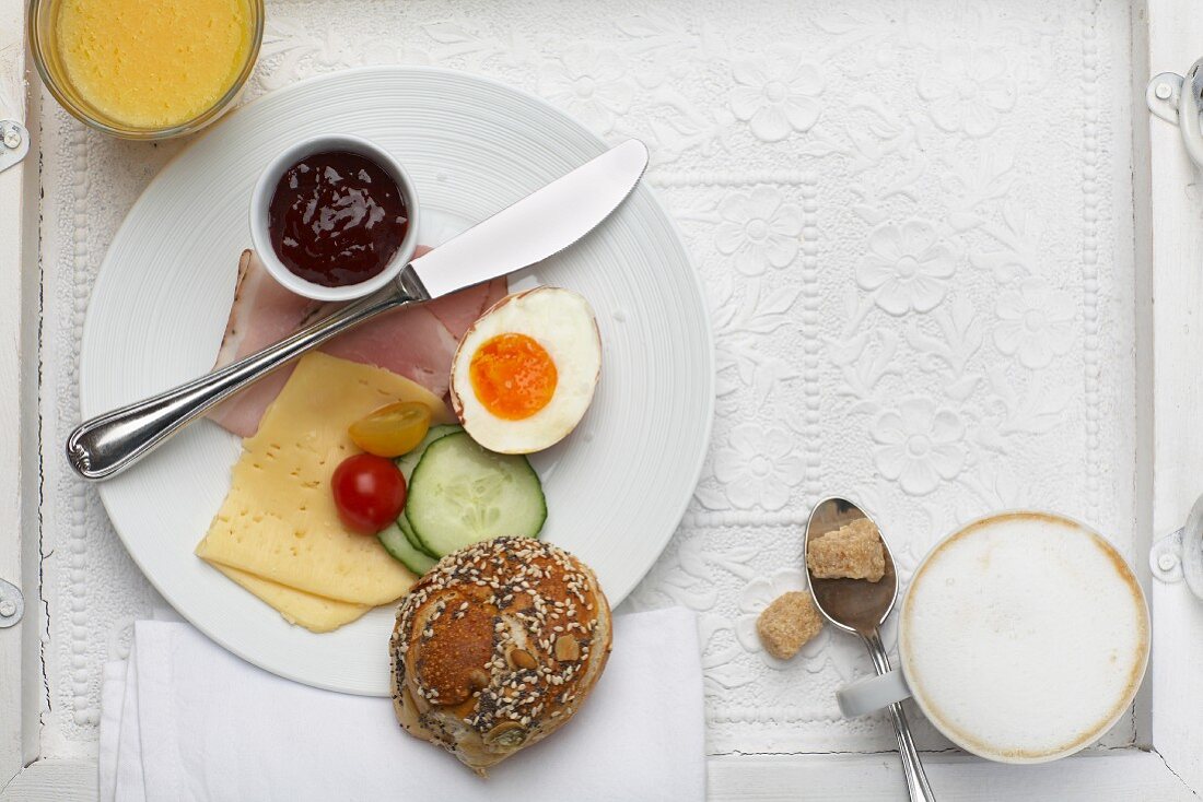 Frühstücksteller mit Schinken, Käse, Ei und Marmelade, Brötchen, Kaffee