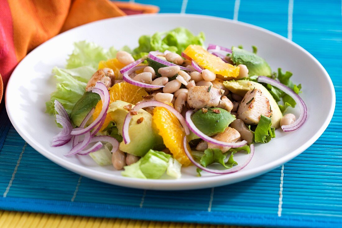 Lukewarm chicken salad with beans, avocado and oranges